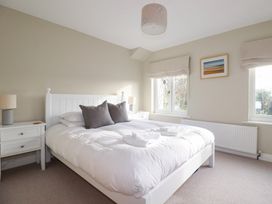A bedroom with a bed and bedside table at The Mizzen St Endellion near Port Isaac