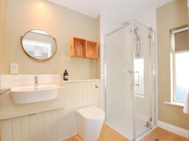 A bathroom with a shower, toilet, and sink at The Mizzen in St Endellion near Port Isaac