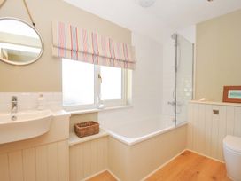 A bathroom with a bath tub and a sink at The Mizzen in St Endellion near Port Isaac