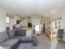 A living room with a kitchen and dining space at Bluebell Lodge in Warton