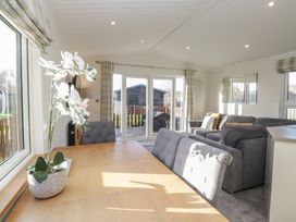 A living room with sofas and dining table at Bluebell Lodge in Warton