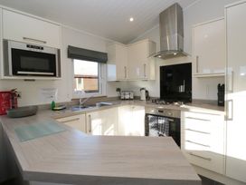 A kitchen with cabinets and appliances at Bluebell Lodge in Warton