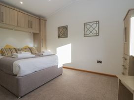 A bedroom with a bed and cabinets at Bluebell Lodge in Warton