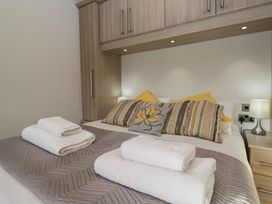 A bedroom with a bed and towels at Bluebell Lodge in Warton
