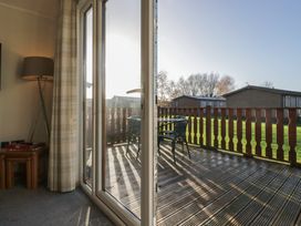 A living room with sliding doors leading to a deck at Bluebell Lodge Warton