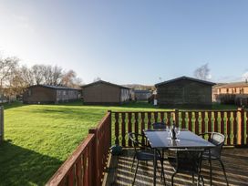 An outdoor seating area with a table and chairs at Bluebell Lodge in Warton