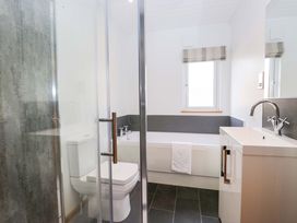A bathroom with a shower, bathtub, toilet, and sink at Bluebell Lodge in Warton
