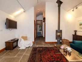 A living room with a television and stove at Owl Cottage in Woodbridge