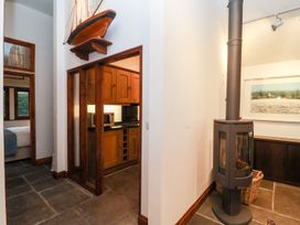 A kitchen with wooden cabinets and a stove at Owl Cottage in Woodbridge