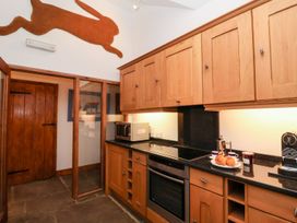A kitchen with wooden cabinets and appliances at Owl Cottage in Woodbridge