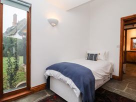 A bedroom with a bed and window at Owl Cottage in Woodbridge