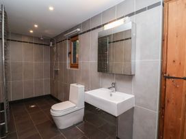 A bathroom with a toilet, sink, shower and mirror at Owl Cottage in Woodbridge
