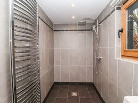 A shower with a towel radiator and a window at Owl Cottage in Woodbridge