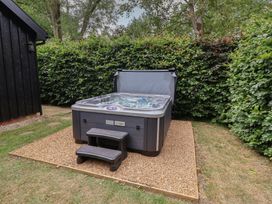 A hot tub with steps in a garden at Owl Cottage in Kettleburgh near Framlingham