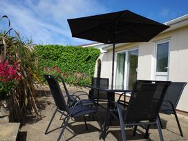 An outdoor seating area with a table and chairs at Badgers Cliff in Polzeath