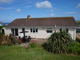 A house with a patio set and plants at Badgers Cliff in Polzeath