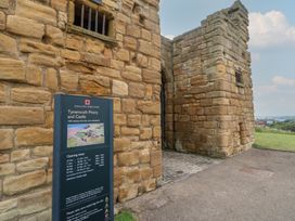 An entrance to Tynemouth Priory and Castle with an information sign in North Shields