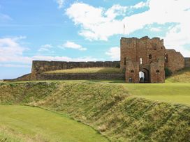 A castle with an archway and grassy hill at Chalet 86 in North Shields
