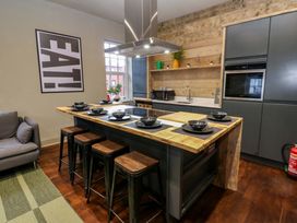 A kitchen with wooden table and stools at Chalet 86 in Tynemouth