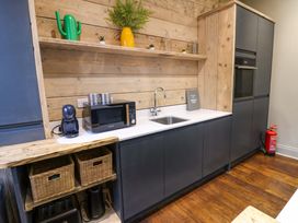 A kitchen with a sink, microwave, and storage baskets at Chalet 86 Tynemouth