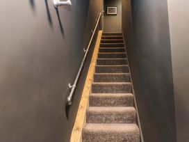 A staircase with a handrail and wall decor at Chalet 86 in Tynemouth