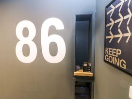 A hallway with number 86 on the wall and a mirror at Chalet 86 Tynemouth