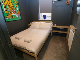 A bedroom with a bed and artwork at Chalet 86 in Tynemouth