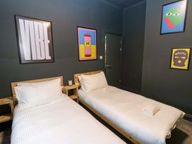 A bedroom with two beds and art on the walls at Chalet 86 Tynemouth