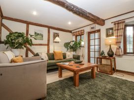 A living room with a sofa, coffee table, and plants at Magpie Cottage in Worcester