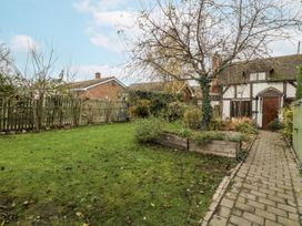 A garden with a tree and a pathway at Magpie Cottage Worcester