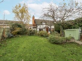 A garden with grass and trees at Magpie Cottage in Worcester