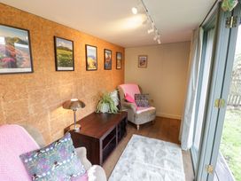 A snug with posters on the wall and a sofa at Magpie Cottage Powick near Callow End