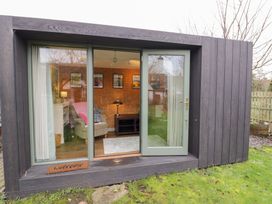 A garden room with sliding door and furniture at Magpie Cottage, Powick near Callow End