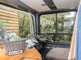 A vehicle cabin with a steering wheel and basket at The Bus on the Hill 