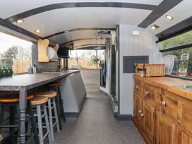 A kitchen with bar counter and stools at The Bus on the Hill 