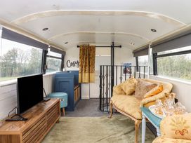 A living room with a television and sofa at The Bus on the Hill