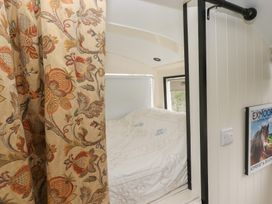 A bedroom with a bed and curtain at The Bus on the Hill