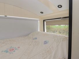 A sleeping area with a bed and windows at The Bus on the Hill