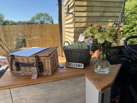 A table with a flower vase and baskets at The Bus on the Hill in Huntsham near Bampton, Devon