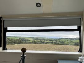 A view from a window showing fields and trees at The Bus on the Hill in Huntsham near Bampton, Devon
