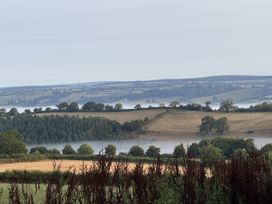 A landscape view with hills and trees at The Bus on the Hill in Huntsham near Bampton, Devon