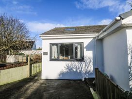 The exterior of a house with a window and sign at Blake Lodge in Crantock