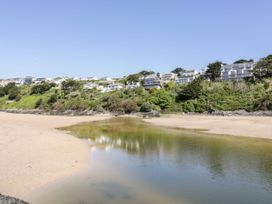 A beach with houses and greenery in the background at Blake Lodge Crantock