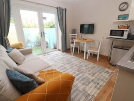 A living room with a sofa and dining table at Blake Lodge in Crantock
