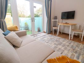 A living room with a sofa and dining table at Blake Lodge in Crantock