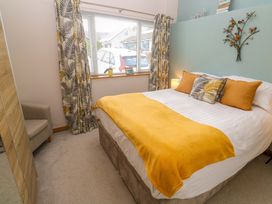 A bedroom with a bed and chair at Blake Lodge in Crantock