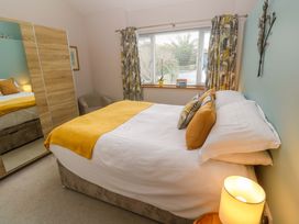 A bedroom with a bed and a mirror at Blake Lodge in Crantock