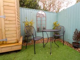 A garden with a table and chairs near a wooden shed at Blake Lodge in Crantock