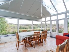A conservatory with a table and chairs at Tresarrett Manor in Bodmin