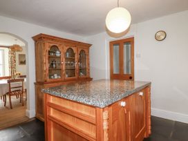 A kitchen with a granite countertop and wooden cupboard at Tresarrett Manor in Bodmin